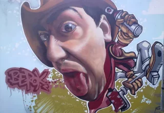 Caricatura hiperrealista de un pintor con sombrero, lengua fuera y bote de spray en la mano