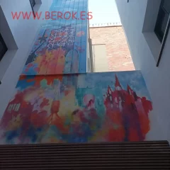 Decoración mural abstracta en patio interior de hotel en Barcelona con skyline de la ciudad.