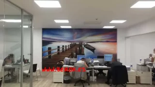 Mural artístico hiperrealista de paisaje costero con muelle, decorando hotel en Sitges.