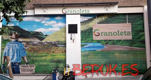 Graffiti en persiana de la tienda Granoletta con paisaje natural y agricultor