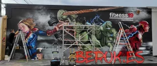 Mural de superhéroes en la fachada del gimnasio Fitness19 en Castelldefels