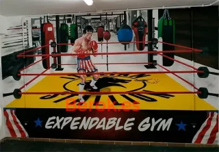 Mural hiperrealista de Rocky Balboa en ring de boxeo decorando gimnasio.