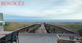 Mural trampantojo hiperrealista de pasarela de madera hacia la playa