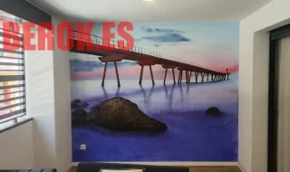 Mural del Pont del Petroli de Badalona al atardecer con olas estilizadas y silueta industrial