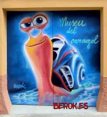 Graffiti de caracol de dibujos animados en la fachada del Museu del Caragol en Lleida, con arte urbano profesional y colores vibrantes.