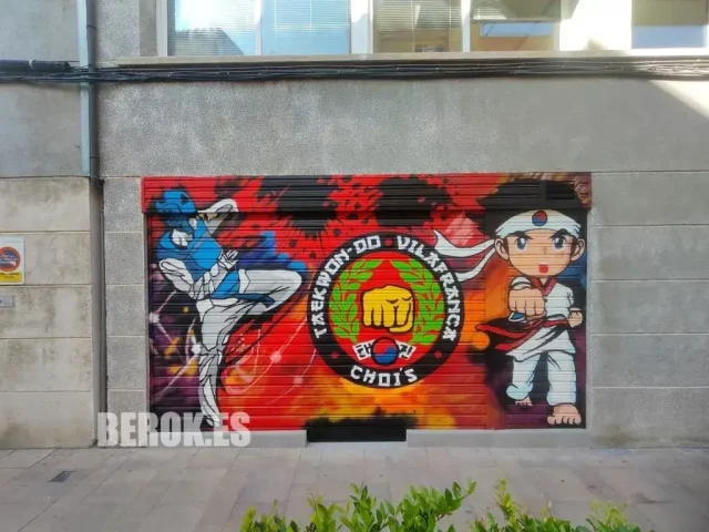 Mural artístico en persiana de escuela de Taekwondo Chois en Vilafranca con personajes animados y logotipo marcial coreano.