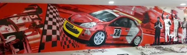 Graffiti mural interior de garaje con coche de rally rojo, bandera a cuadros y pilotos celebrando.