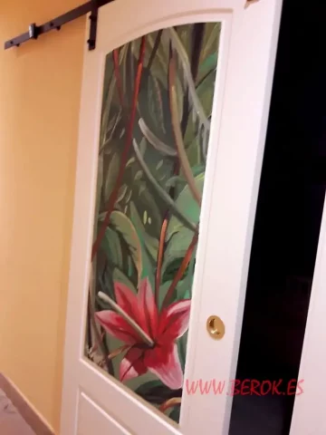 Pintura mural puerta interior con flor tropical roja Pintura mural en puerta interior con flor roja tropical y fondo verde de hojas.
