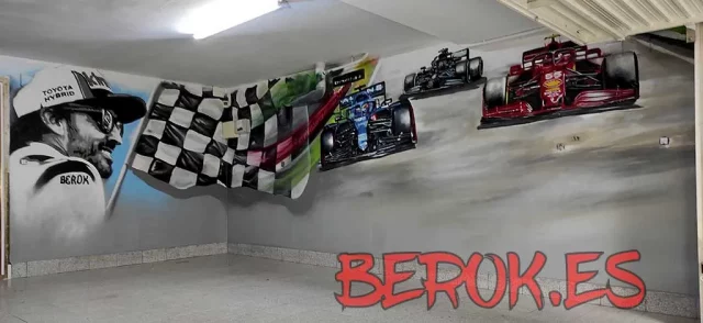 Mural interior garaje Fórmula 1 con coches de competición Mural interior Fórmula 1 en garaje con coches Ferrari y Toyota, bandera a cuadros y piloto.