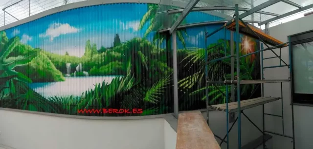 Mural exterior de selva tropical en fachada metálica