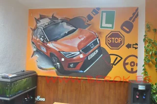 mural graffiti interior de autoescuela con coche naranja, señales de tráfico y símbolos de conducción