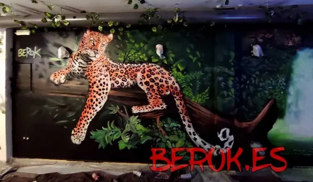 Graffiti de jaguar descansando en rama en la selva