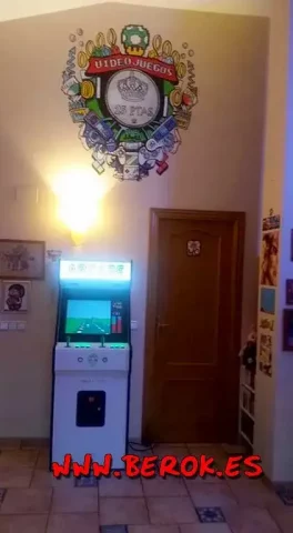 Mural videojuegos retro arcade 25 pesetas Mural interior videojuegos retro 25 pesetas con mandos arcade y máquina recreativa iluminada.