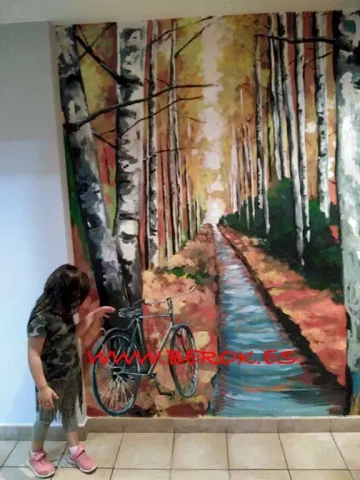 Mural bosque otoñal con bicicleta en interior Mural interior bosque otoñal con camino, árboles altos y bicicleta apoyada.
