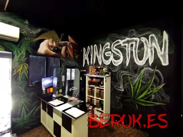Mural artístico asociación cannabis Kingston Graffiti mural interior con hojas de marihuana, humo y texto Kingston en letras grandes.