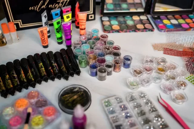 Mesa con maquillaje flúor y purpurina para evento temático en Barcelona