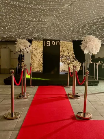 Alfombra roja con decoración dorada en evento temático estilo Oscars