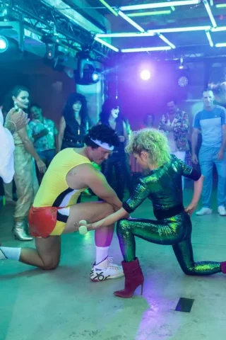 Fiesta temática años 80 con disfraces retro en evento corporativo