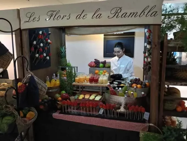 Puesto de frutas y zumos en evento temático Les Flors de la Rambla en Barcelona.