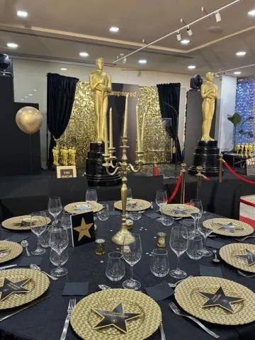Decoración temática Oscars en evento corporativo con estatuillas doradas y mesas elegantes en Barcelona.