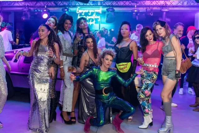 Grupo en fiesta temática 80s 90s en Barcelona con DeLorean y disfraces retro