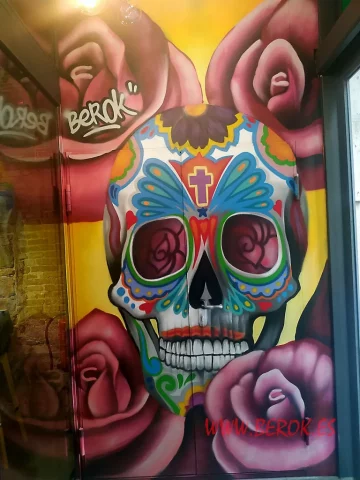 Mural de calavera mexicana con rosas en restaurante temático