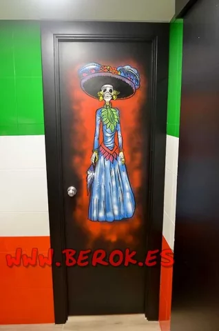 Graffiti Catrina en puerta de lavabo restaurante mexicano
