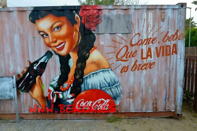 Graffiti publicitario CocaCola con mujer mexicana y mensaje positivo