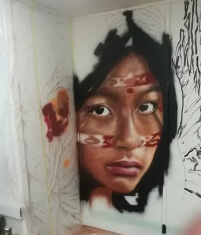 Graffiti hiperrealista niña indígena mural interior Graffiti hiperrealista retrato de niña indígena en mural urbano