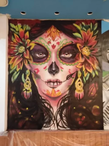 Graffiti Catrina mexicana con flores en mural interior