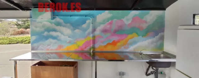 Mural de nubes multicolor con tonos pastel en pared de caravana