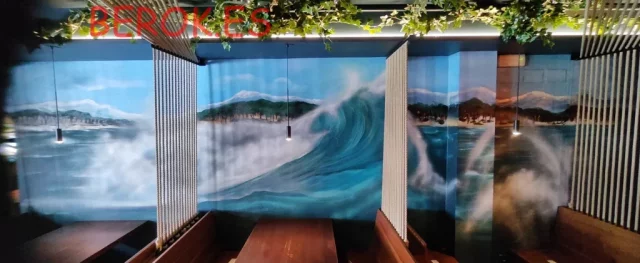 Mural con olas y paisaje costero en restaurante La Escala