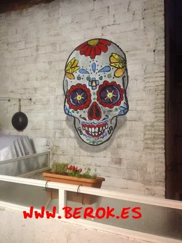 Graffiti calavera mexicana en pared de ladrillo