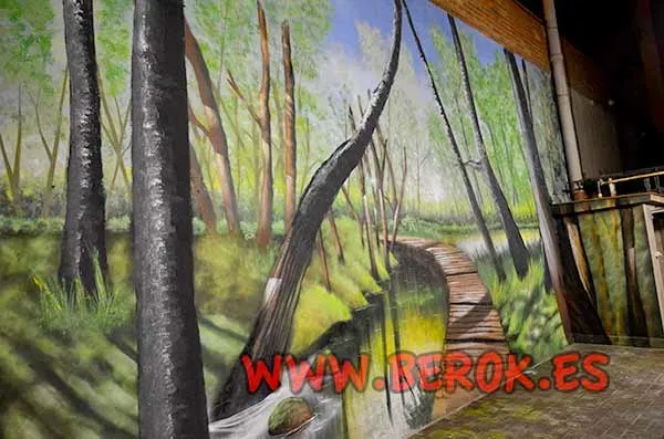 Graffiti mural de bosque con puente de madera y profundidad pintado en fachada de patio.