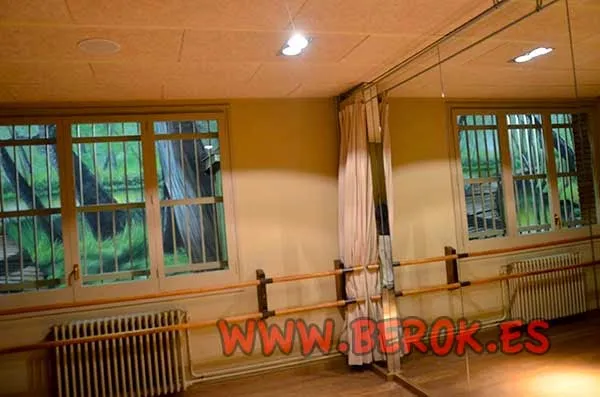 Murales de graffiti en patio interior vistos desde sala con espejos y ventanas.