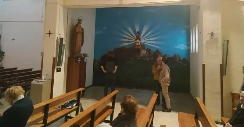 Mural de la Virgen de Montserrat con fondo de montaña y rayos de luz