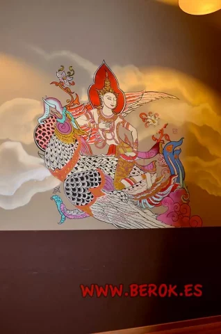 Mural tailandés con ángel mitológico y aves de colores
