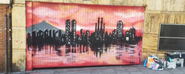 Graffiti skyline de Barcelona con tonos rosados y edificios icónicos