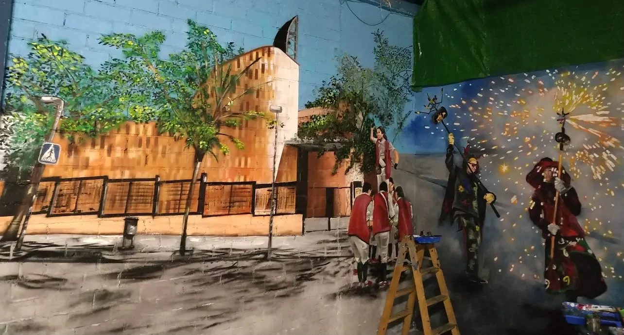 Mural de interior en Barcelona con dimonis, fuego, chispas y gente en fiesta mayor catalana.