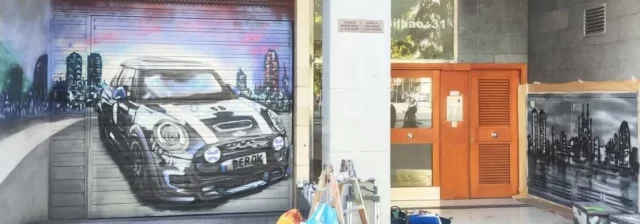 Graffiti de Mini negro en persiana con paisaje de Barcelona