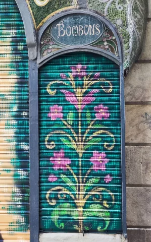 Decoración floral modernista en persiana lateral Motivo floral modernista pintado en persiana lateral de pastelería en La Rambla