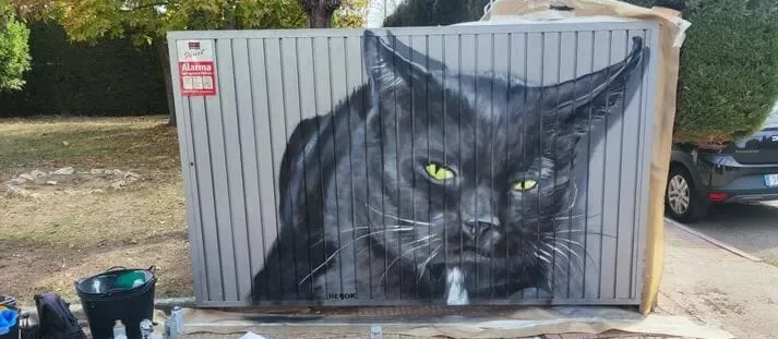 Graffiti de gato negro realista pintado en puerta exterior metálica