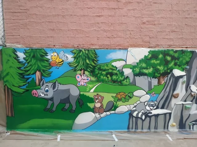 Animales del bosque en mural infantil escolar Mural infantil de animales del bosque con jabalí, tortuga y mariposa en escuela.