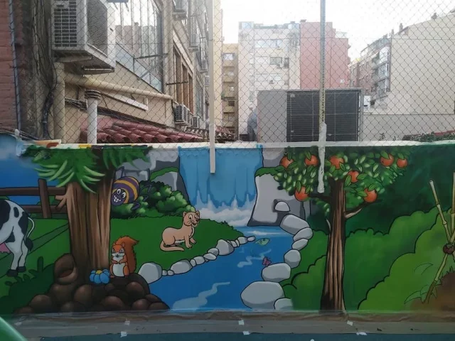 Mural infantil de naturaleza y animales en patio escolar Mural infantil en patio de escuela con río, cascada, animales y paisaje natural.