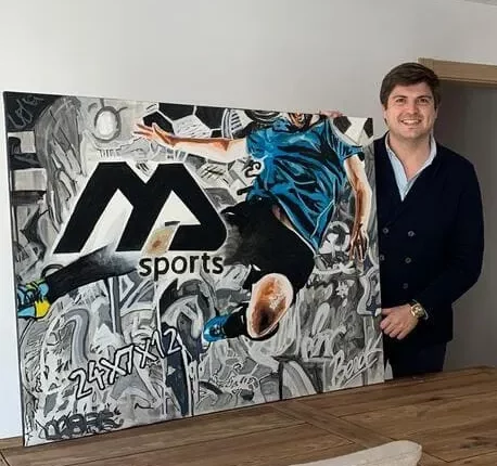 Cuadro M Sports con futbolista en acción y fondo urbano