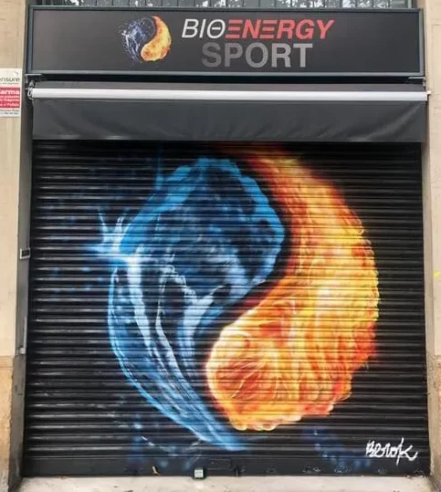 Graffiti en persiana de gimnasio Bio Energy Sport con esfera de fuego y agua