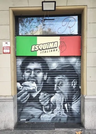 Graffiti realista en persiana metálica estilo retrato Graffiti realista en persiana metálica con retratos icónicos del imaginario italiano