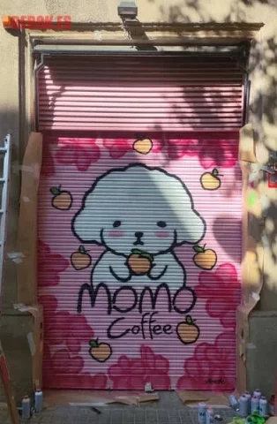 Graffiti kawaii en persiana de cafetería asiática Momo Coffee Graffiti kawaii en persiana de Momo Coffee, coffee store y cafetería asiática, con perrito blanco y melocotones rosas en Barcelona