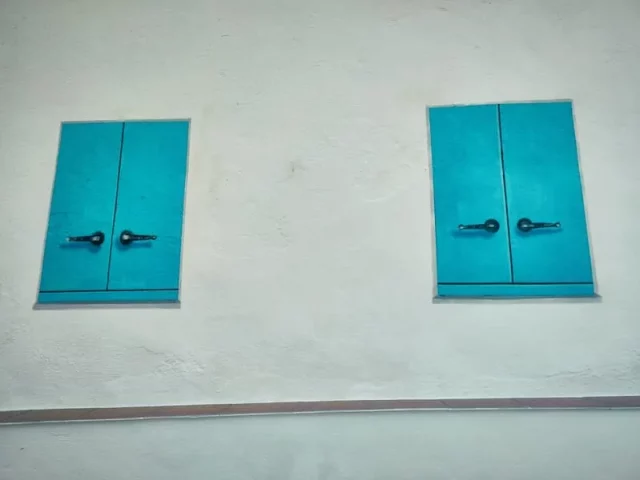 Mural trampantojo de ventanas azules en pueblo de pescadores