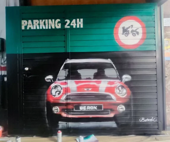 Mural urbano de coche clásico en parking Graffiti de coche Mini rojo pintado en persiana de parking en Barcelona